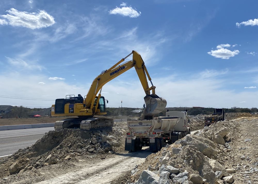 An excavator fills hauling trucks at US 290 near Convict Hill Road. Crews are currently excavating rock and dirt from this area. April 2022